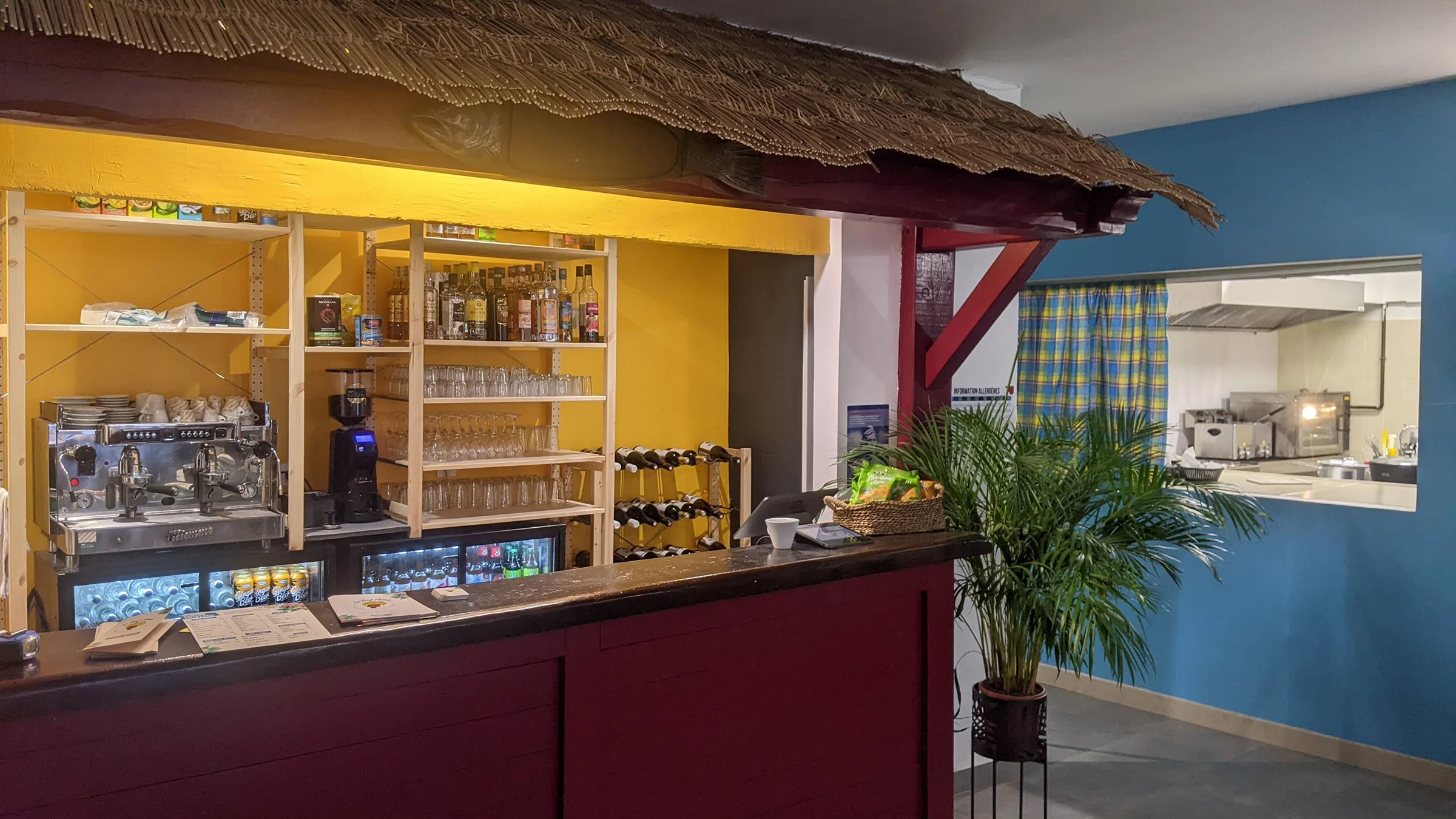 Comptoir du bar avec rhums arrangés et ti punch, ambiance antillaise conviviale